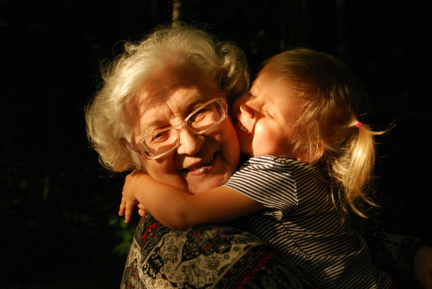 A grandmother and granddaughter looking at a photo album together
